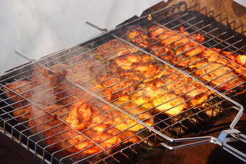 Appetizing crisp mix meat barbecue on a metal grid in the grill  closeup in winter on white snow background - nature activities, party, recreation, healthy food