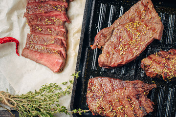 Grilled beef steak on frying pan, top view. Fried chunks of meat close up