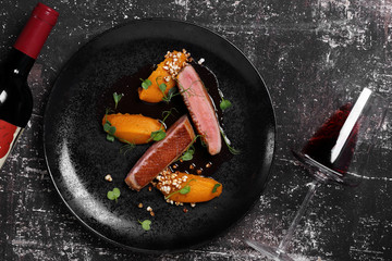 утиная грудка на черном блюде с красным вином