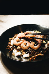 Delicious meal with shrimps in black plate, traditional Aisan food
