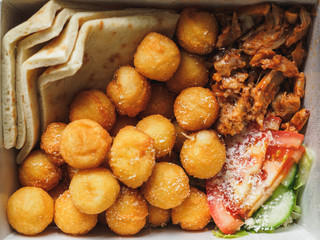 open gyros with chicken, potato balls, pita and vegetables