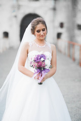 Naklejka premium Portrait of stunning bride with long hair posing with great bouquet