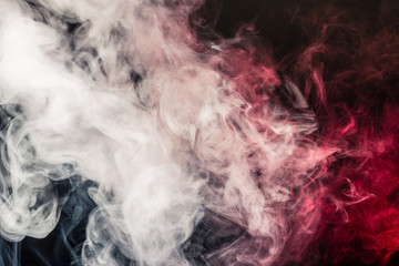 Colorful smoke on a black background of red and white colors. The concept of smoking. Beautiful textural background