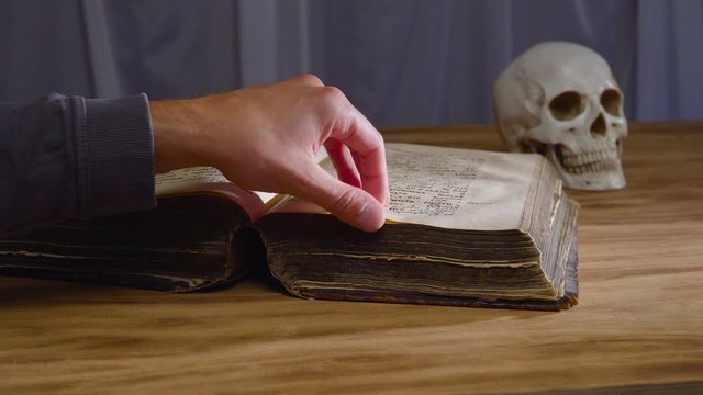the magic rite. Ancient book and human skull. Concept for Halloween