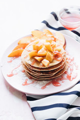 Stack of delicious homemade pancakes with sauce and sliced apple