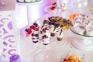 Delicious sweets on wedding candy buffet with desserts, cupcakes