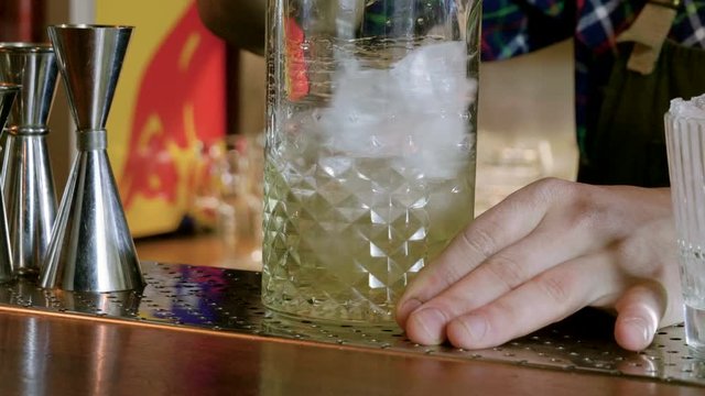 The barman serving a mixed alcoholic drink in a bar. White negroni cocktail. 4K