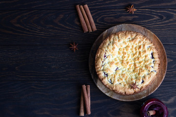 Homemade tasty shortcrust pie with fruit or jam, crumble and spices (cinnamon, anise) on old wooden...