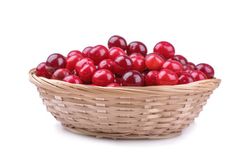 Ripe red fresh cherry in a wicker basket on a white isolated background