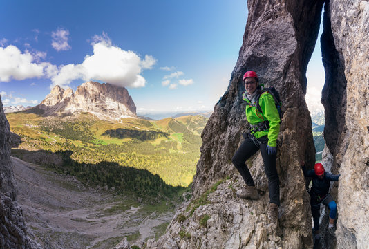 two young attracttive female mountain climber in the Dolomites of italy with a great panorama view of the Langkofel and Passo Sella