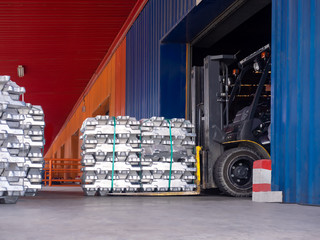 Close up aluminium ingot in bundle handling by forklift in warehouse.Moving aluminium ingot in bundle for stuffing.