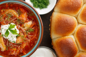 National ukrainian red borscht with sour-cream and buns pampushki.