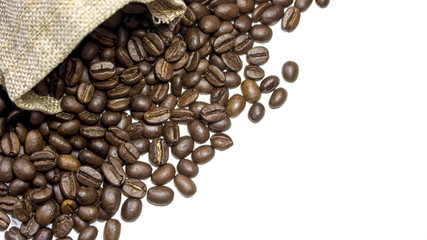 Beautiful coffee beans pouring out of burlap sack and into white surface. With copy space.