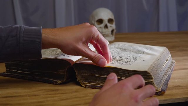 the magic rite. Ancient book and human skull. Concept for Halloween