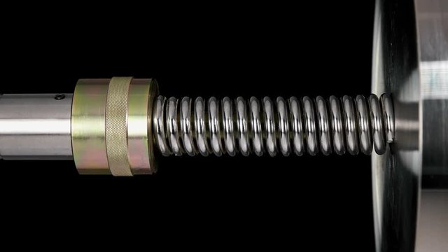 test of reliability of a spring, compression and decompression by a hydraulic press, close-up
