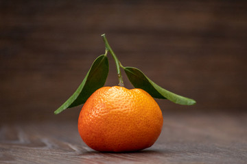 Orange Mandarin Fruit with Green Leaves on a Wooden Table