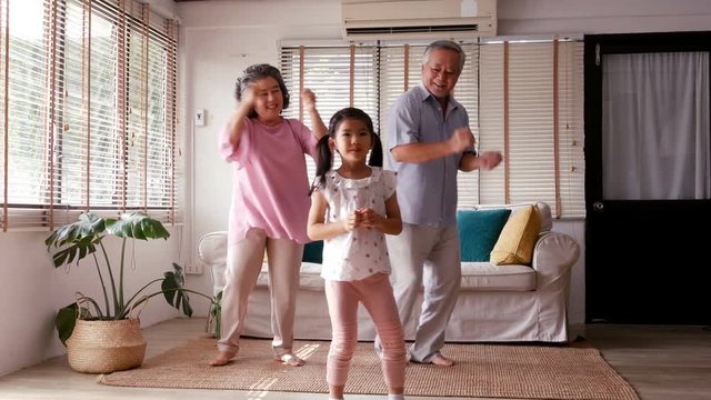 Senior man woman and kid dancing together at home. People with relax time at home.