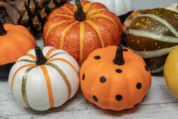 Pile of colorful decorative pumpkins in orange, black, and white colors. Useful for Halloween and autumn concepts