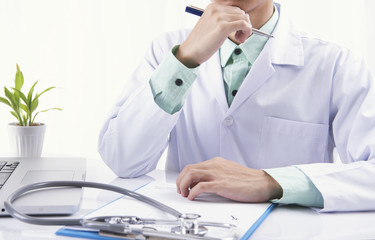 doctor sitting in medical office with device stethoscope and paper diagnose.