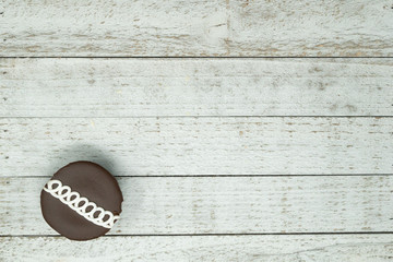 Chocolate swirled decorated cupcake with blue napkin on wood background