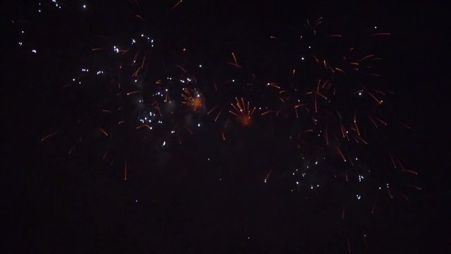 Festive salute in slow motion. Fireworks in the night sky. Multicolored light flashes on a dark background
