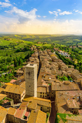 Aerial view of the historic town of San Gimignano with beautiful landscape scenery on a sunny summer day in Tuscany, small walled medieval hill town with towers in the province of Siena, Italy - obrazy, fototapety, plakaty