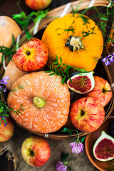 Autumnal colorful  pumpkins, apples and figs  on rustic background, Hallloween or Thanksgiving concept