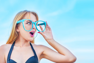 Cute girl in big glasses enthusiastically watching opening
