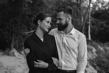Husband and wife look at each other for a walk in the forest
