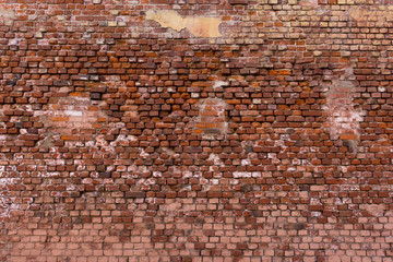 old brick wall with traces of repair and plastering
