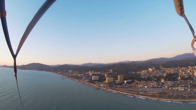 Parachute flight tied to a boat over the Black Sea in a beautiful sunset, first-person view, extreme entertainment