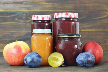 Fruit jam jars on wooden background