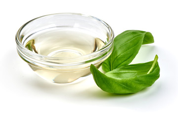Obraz na płótnie Canvas Vinegar in glass bowl with basil leaves, isolated on white background