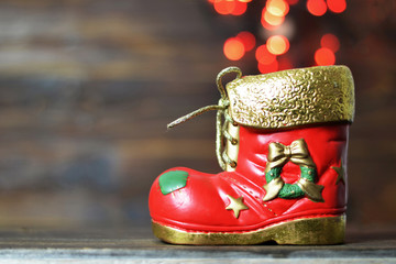 Christmas boot and blurred lights in background. Christmas boot on wooden background with copy space