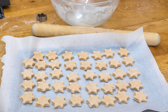 Domestic Home Baking: Messy Arrangement Of Star Shaped Cinnamon Christmas Cookies On Kitchen Bench With Cutter, Rolling Pin And Mixing Bowl