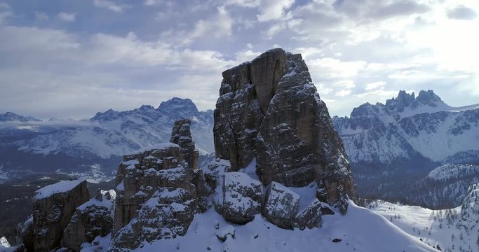 Orbit aerial around majestic Cinque Torri rocky snow mounts. Sunny day with cloudy sky.Winter Dolomites Italian Alps mountains outdoor nature establisher.4k drone flight