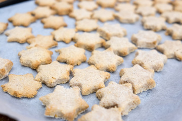 Crumbly messy star shaped cinnamon Christmas cookies lightly baked till golden brown