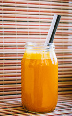 Fresh pumpkin juice isolated on bamboo background