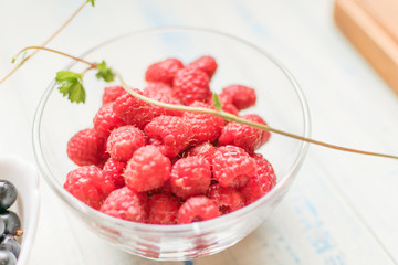 Raspberries in a glass plate.