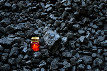 Vigil light, candle on cheap of coal - obrazy, fototapety, plakaty