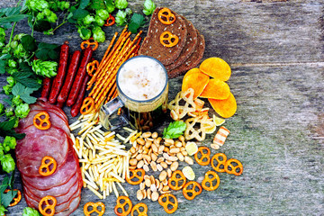 Oktoberfest food menu. Sausages, beer snacks, pretzels, a glass of beer on a wooden background. Oktoberfest mood.