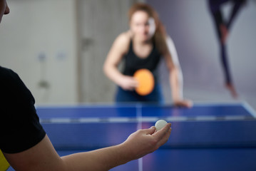 People playing ping pong tennis at gym room. Happy man and woman playing table tennis