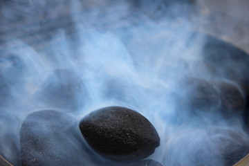 Black coals in white smoke in the grill