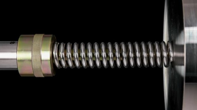 test of reliability of a spring, compression and decompression by a hydraulic press, close-up