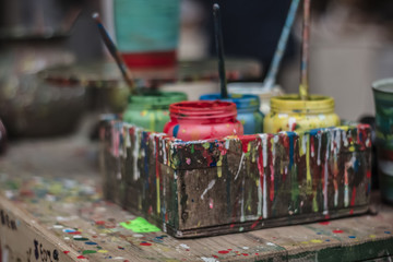 colorful paint bottles and jars with spilled paint for pottery