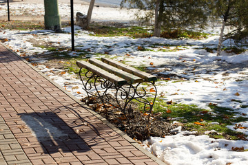 Bench in snow covered winter town yard