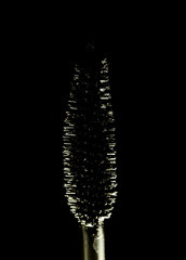 and black mascara brush isolated on black