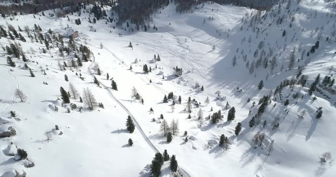 Forward aerial over snowy plain and snow valley with ski tracks at Cinque Torri mounts. Sunny day with cloudy sky.Winter Dolomites Italian Alps mountains outdoor nature establisher.4k drone flight