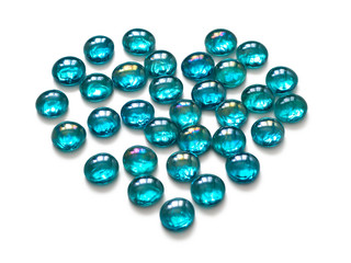 Bright glass stones, turquoise color, lined in the shape of a heart. Isolated on white background