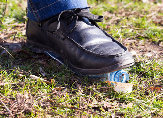 human trampled with the feet of plastic mineral water bottles and bottle caps on the grass in the park, the concept of environmental protection, fouling the environment